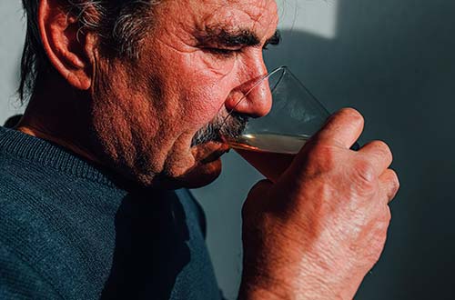 мужчина пьет алкоголь из стакана